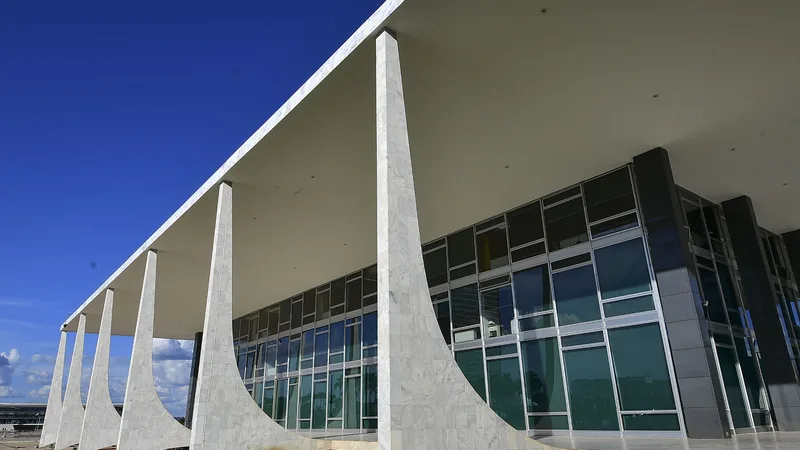 Colunas brancas da fachada do prédio do Supremo Tribunal Federal sob céu azul
